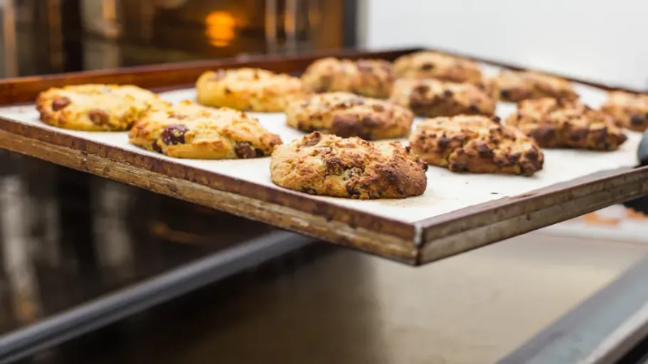 Frisch gebackene Kekse auf Blech, in Küche.