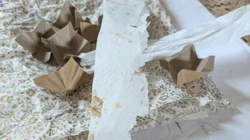 Brown paper boats on floral paper surface.