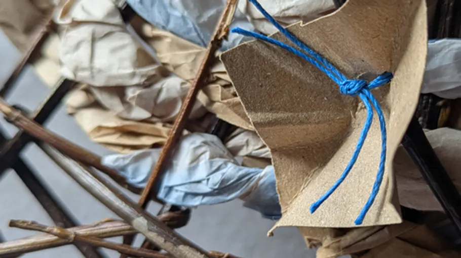 Brown paper flower tied with blue string.