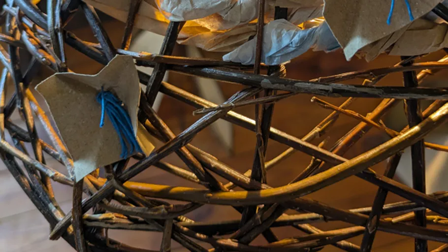 Geflochtener Korb mit Papierdekorationen innen.