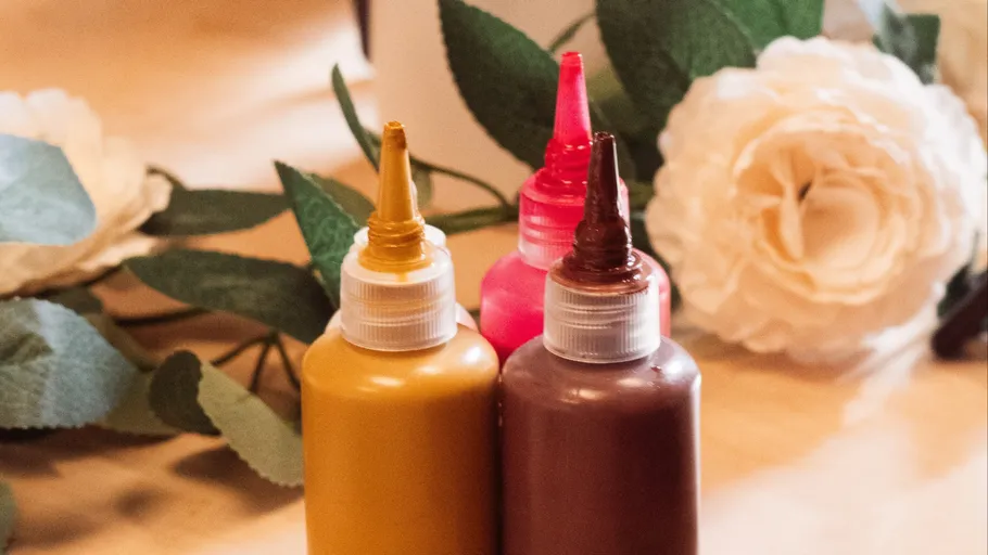 Color bottles on a table with flowers.