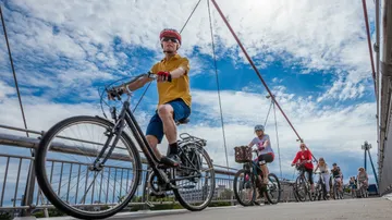Cyclists riding across a suspension bridge.