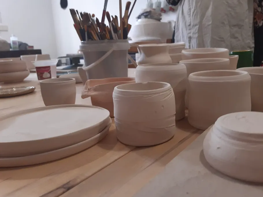 Clay objects lie on a table in an art studio.