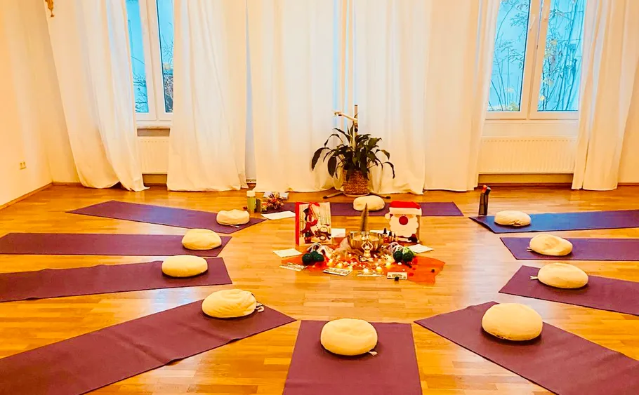 Meditationsraum mit Matten und Kissen im Kreis.