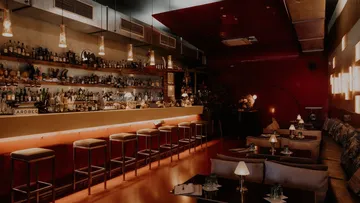 Modern lounge bar with cozy seating and dim lighting.