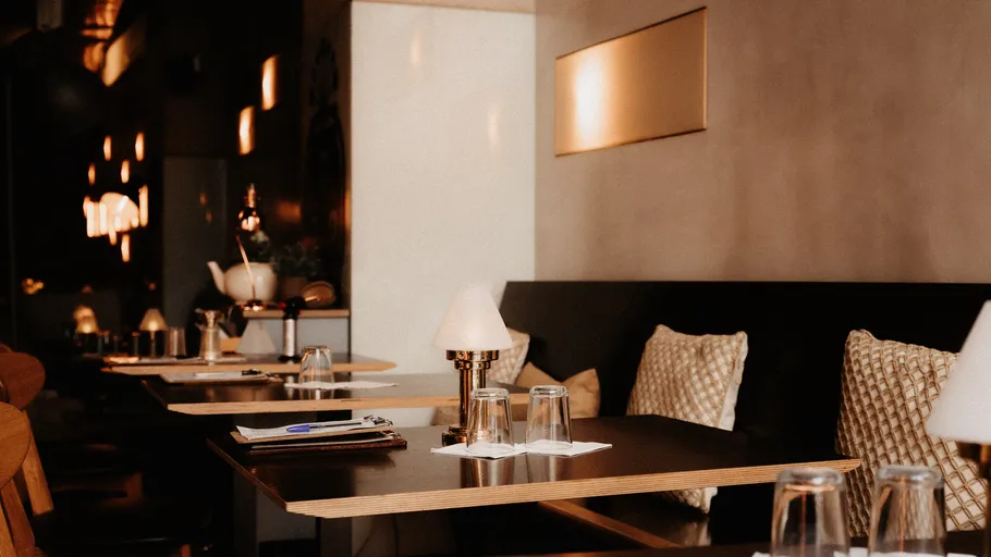 Leere Restauranttische mit Lampen, schummrig beleuchtet.