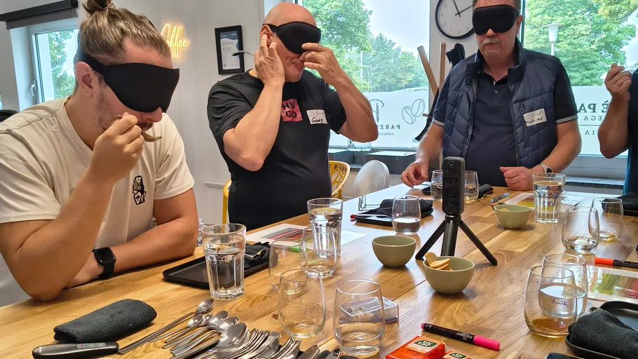 Blinde Männer probieren Essen am Tisch.