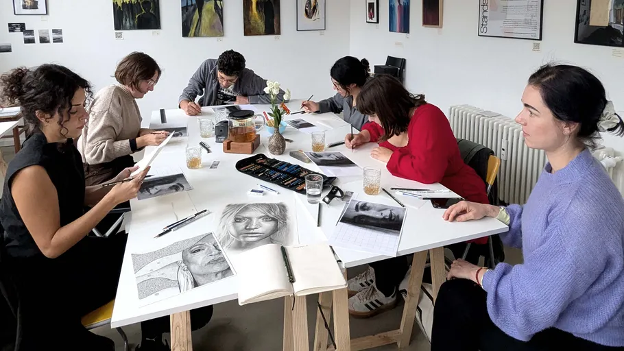 Group drawing portraits at a table.