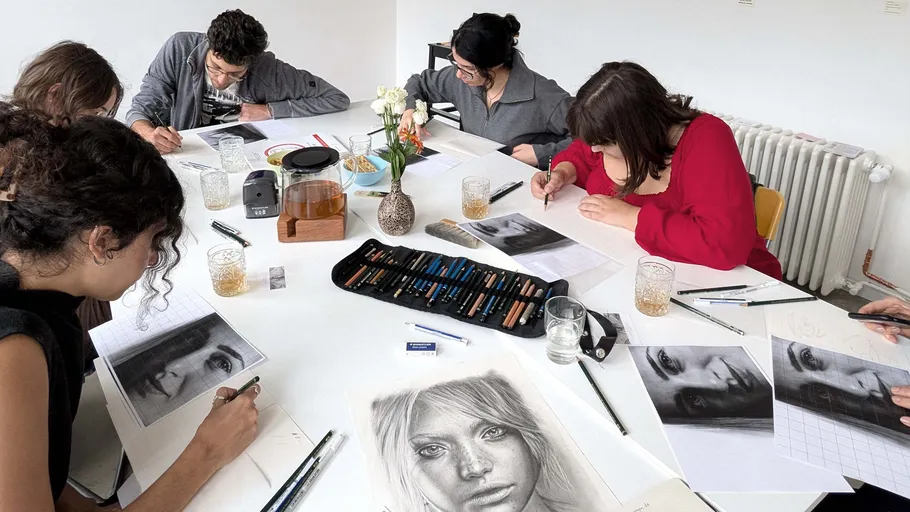 People drawing portraits at a table.