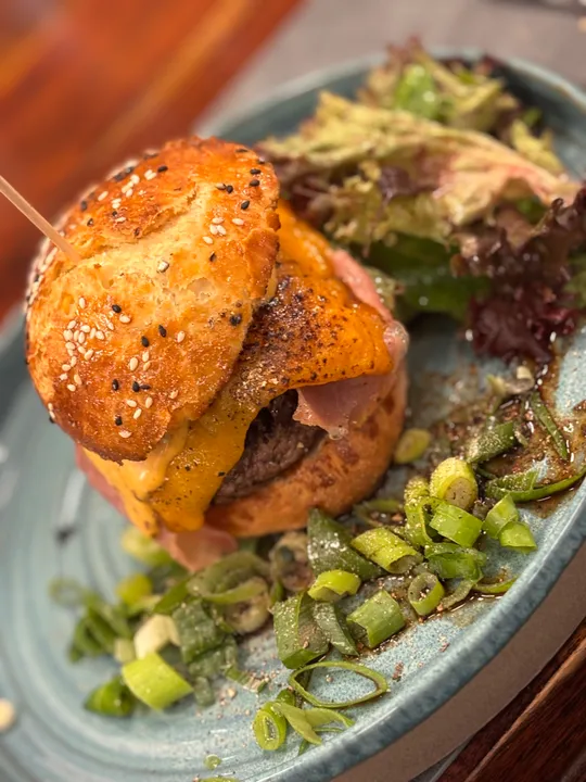 Burger mit Käse auf einem Salatteller.