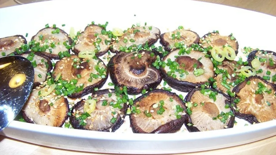 Mushroom slices with chives in a dish.