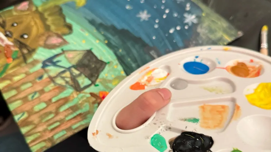 Palette held over painting of animals.
