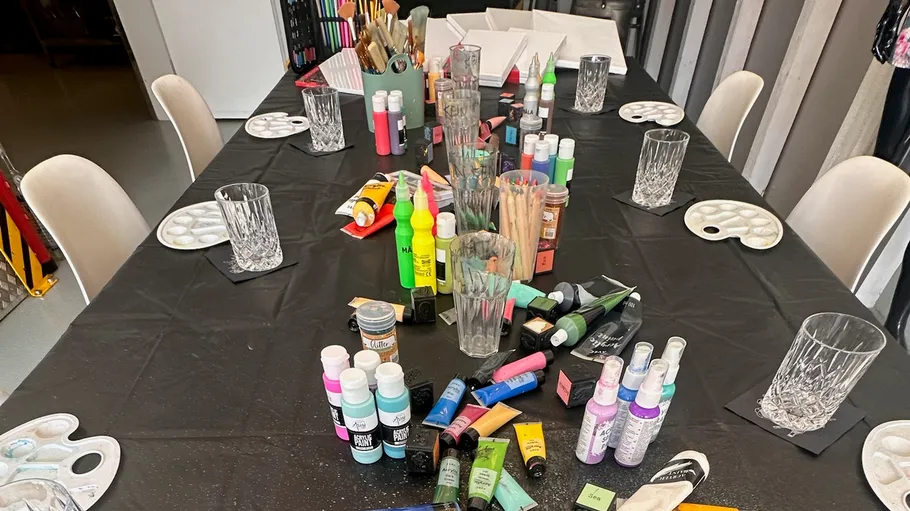 Art supplies on table with black cloth.
