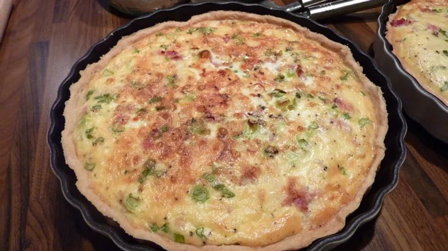 Quiche in a baking pan on table.