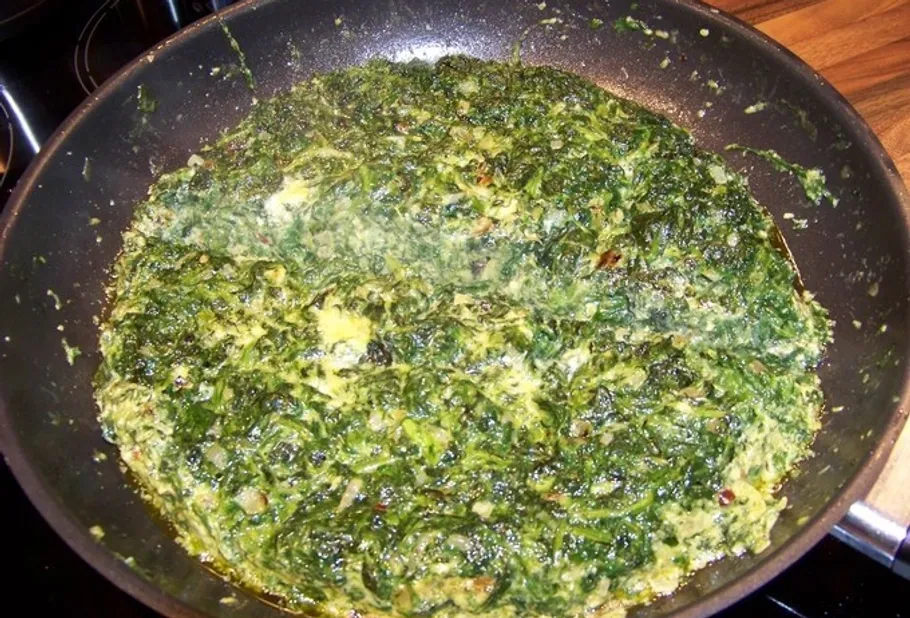 Spinach dish cooking in a frying pan.