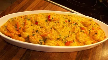 Garnelen in gelber Sauce, in weißer Schale.