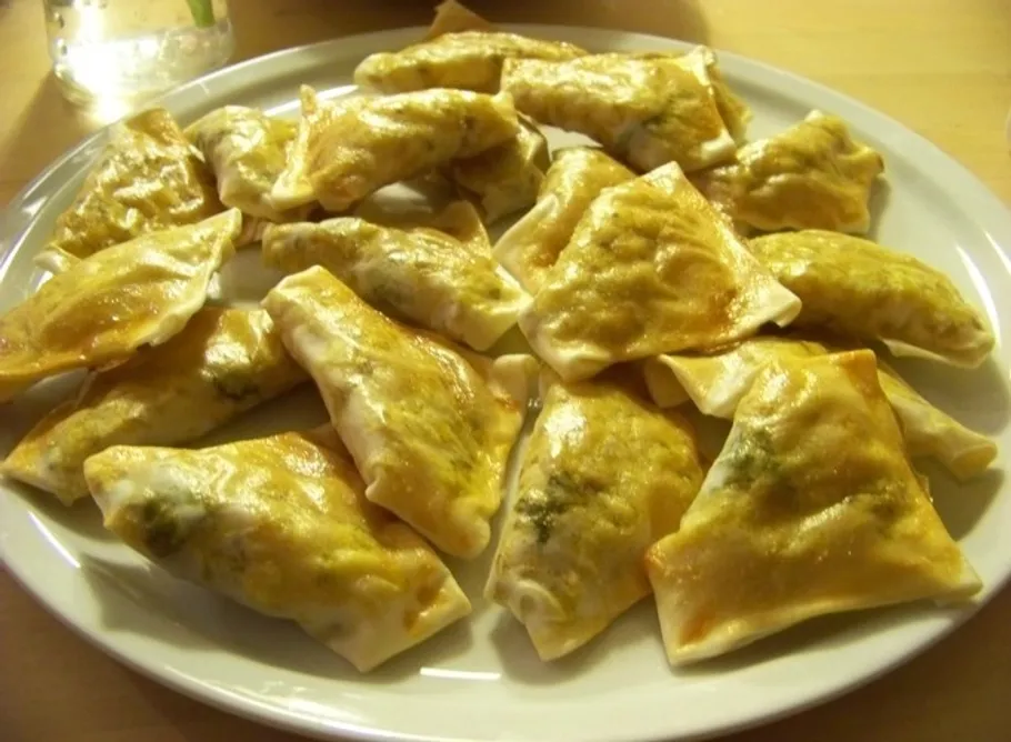Plate of baked dumplings on a table.
