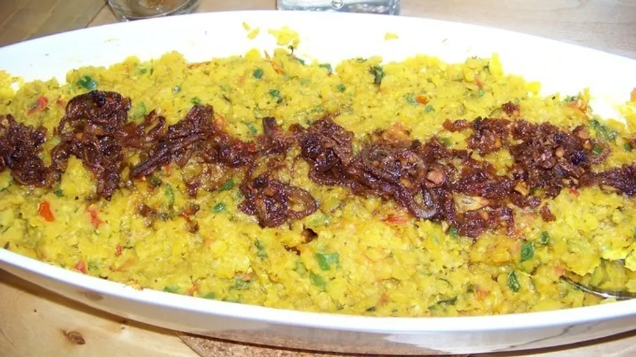 Mashed vegetables topped with fried onions presented in a dish.