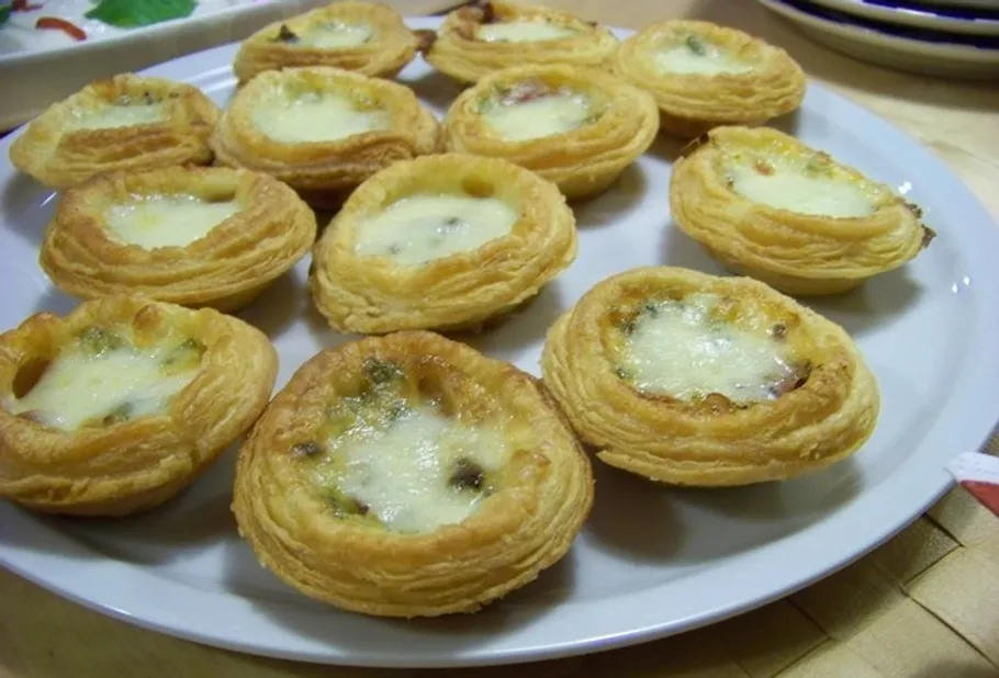 Mini-Käsetörtchen auf weißem Teller.