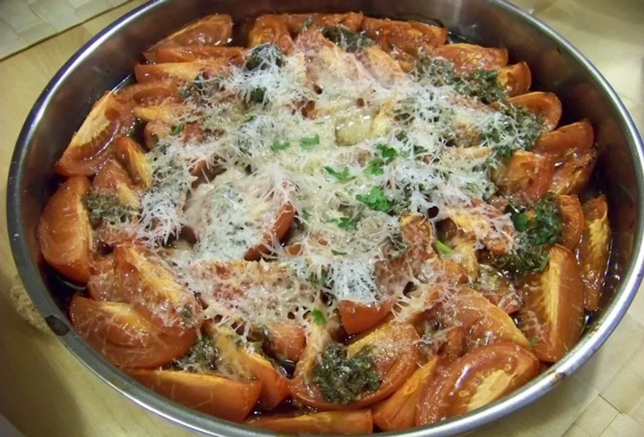 Tomato wedges baked with cheese in a pan.