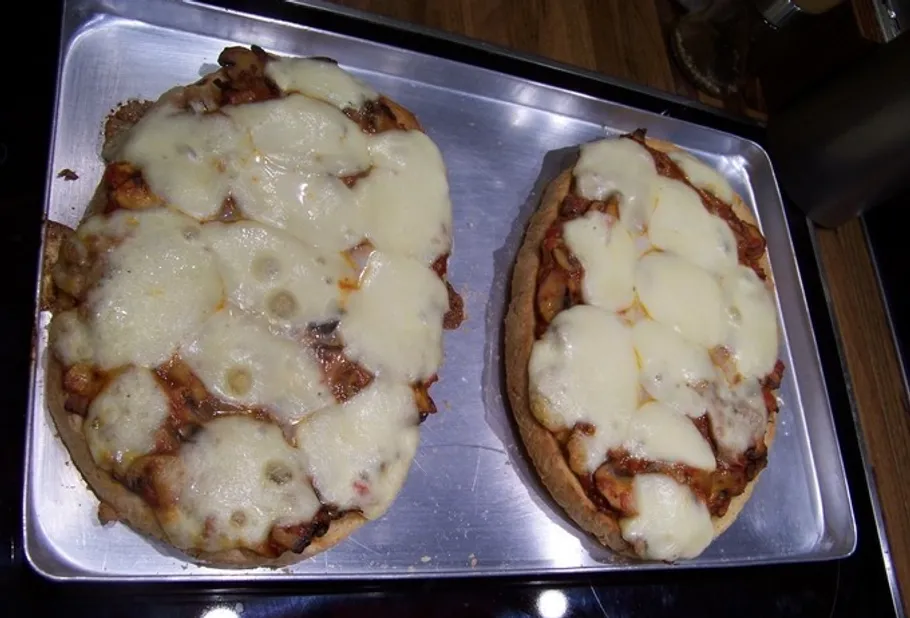 Zwei Käse-Pizzen auf einem Backblech.