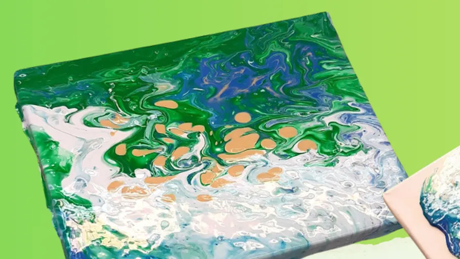 Hands tilting canvas with vibrant paint pour.