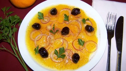 Plate with oranges, olives, onion, and parsley garnish.