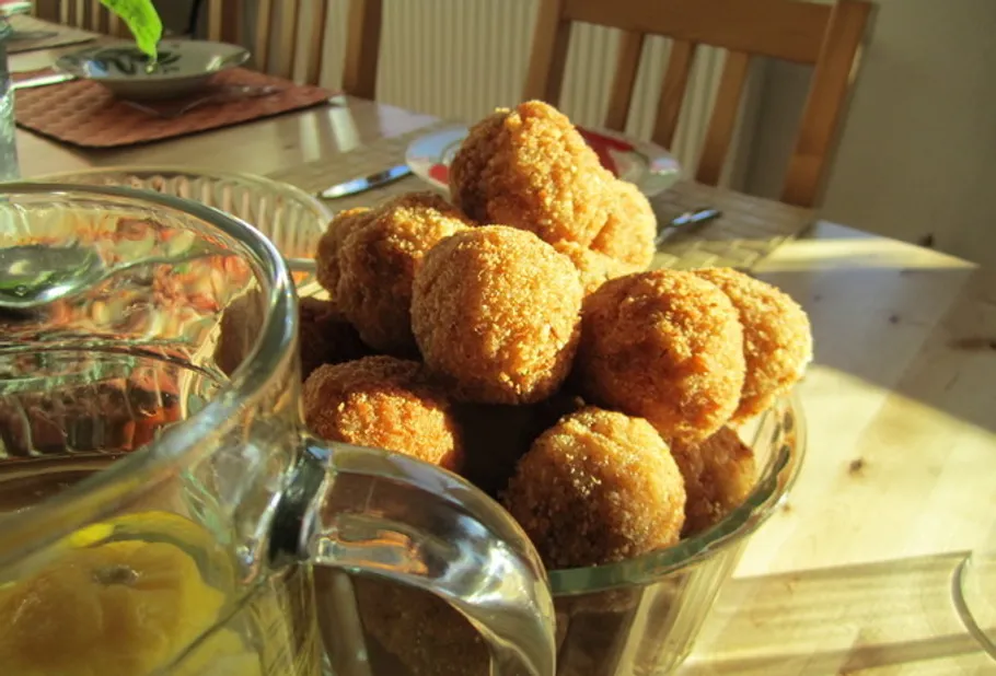 Breadcrumb-coated balls in a bowl on a table.