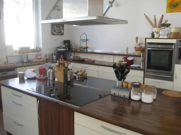 Moderne Küche mit Holzarbeitsplatten und Utensilien.