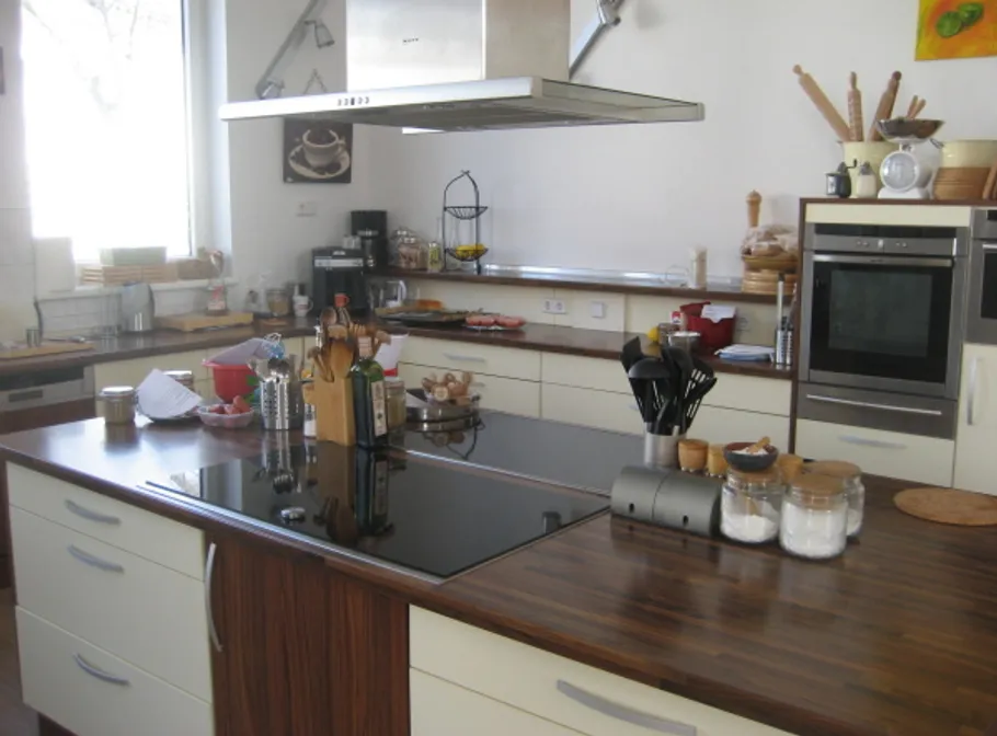 Modern kitchen with wooden countertops, utensils, and appliances.