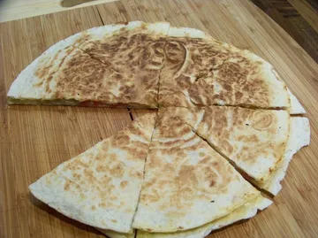 Geschnittene Quesadilla auf Holzbrett.