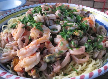 Meeresfrüchte-Pasta mit Kräutern auf Teller.