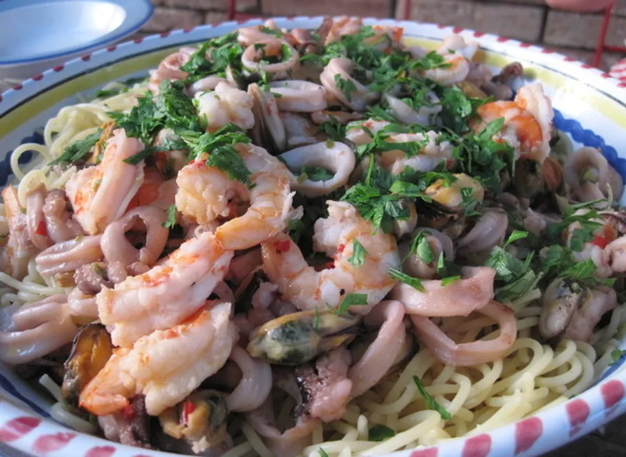 Seafood pasta with herbs on a plate.