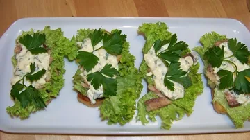 Open sandwiches with lettuce, topping on platter.