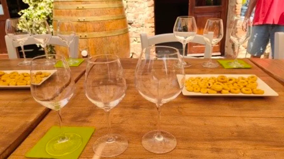 Weingläser auf rustikalem Tisch im Freien.