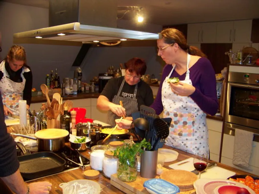 People cooking together in a modern kitchen.