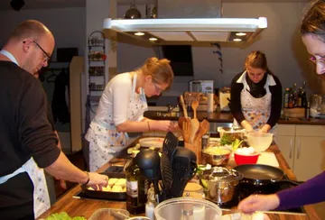 Menschen kochen zusammen in einer Küche.