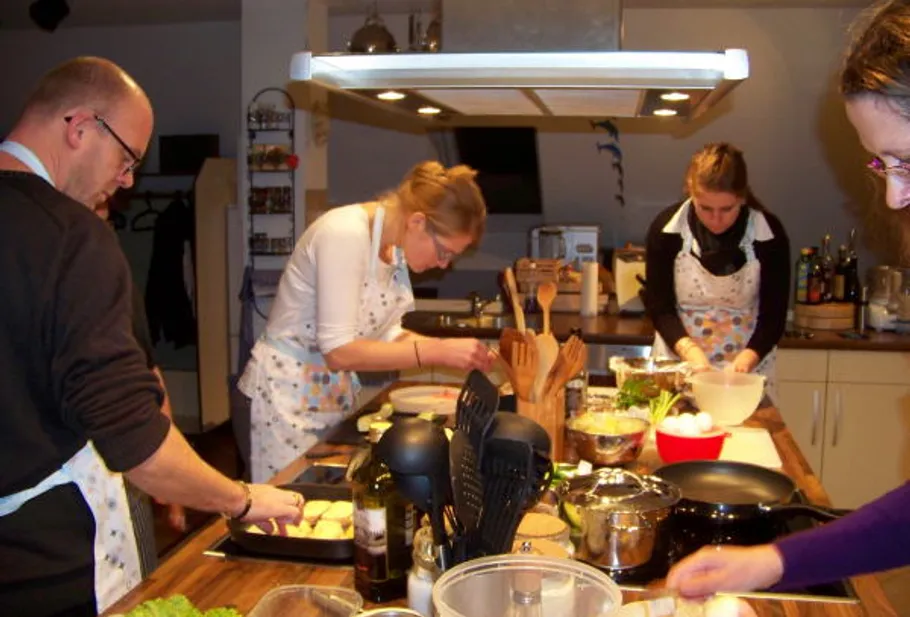 People cooking together in a kitchen.