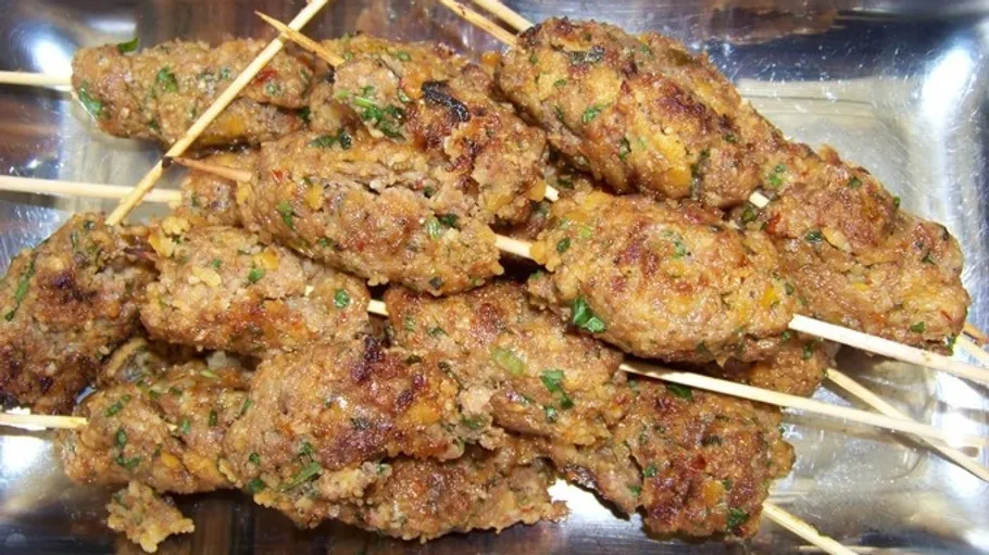 Grilled meat skewers on a rectangular tray.