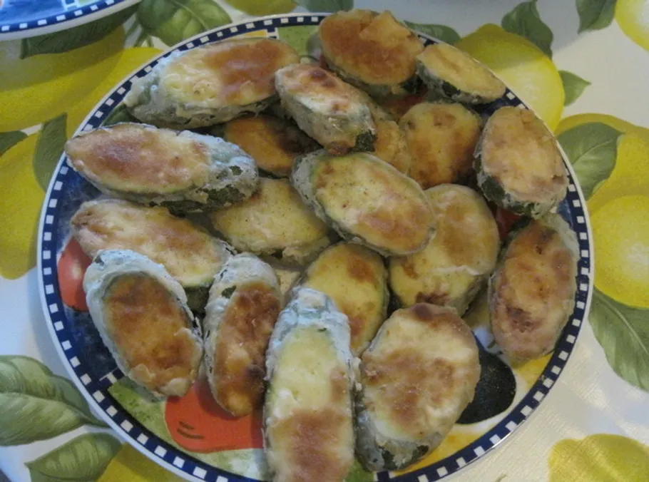 Breaded zucchini slices on decorative plate.