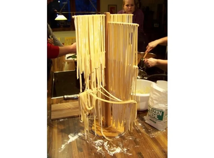Pasta hanging on wire racks in a kitchen.