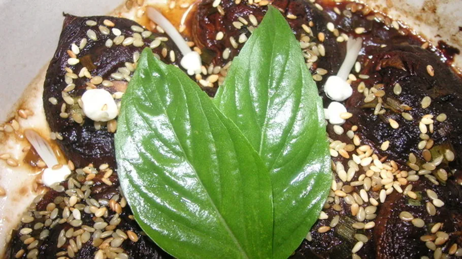 Leaves and seeds on top of dark dish.