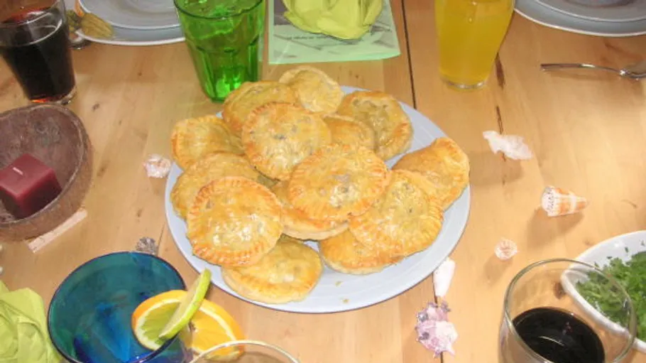 Plate of pasties on a wooden table.