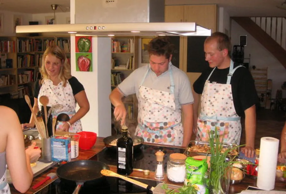 People cooking together in a modern kitchen.