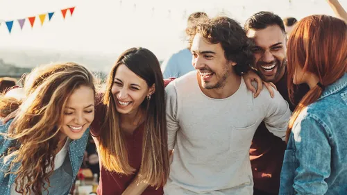 Group of people laughing at outdoor event.