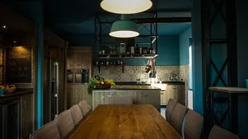 Rustic kitchen with wooden table, ambient lighting.