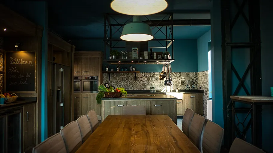 Rustic kitchen with wooden table, ambient lighting.