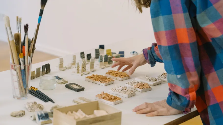 Person arranging clay samples on a table.