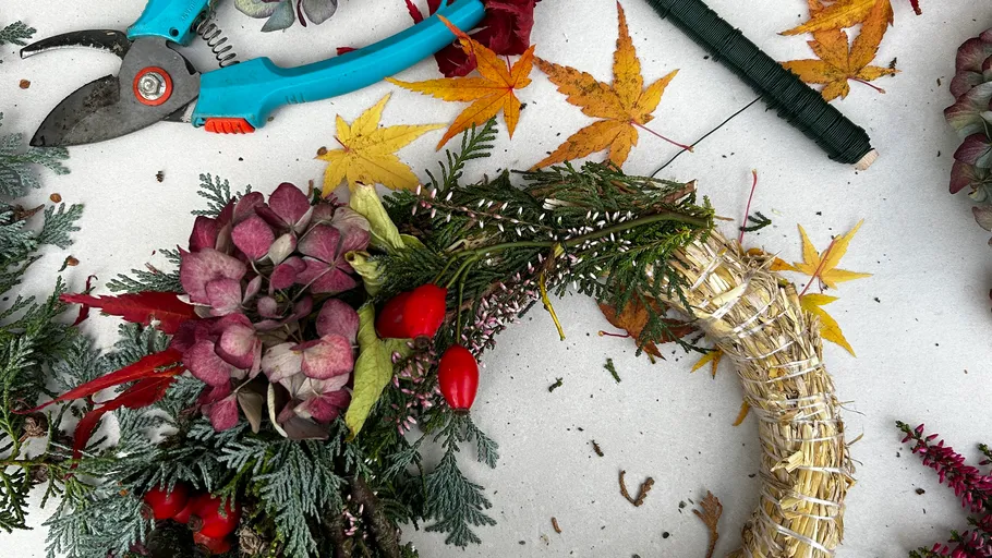 Kranzherstellung mit Blumen und Blättern.
