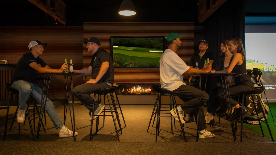People socializing at a bar in golf lounge.